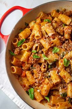 a pan filled with pasta and sauce on top of a table