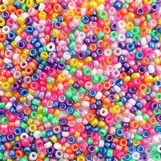 multicolored beads are scattered together on a white surface