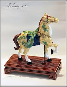 a horse made out of legos sitting on top of a wooden box