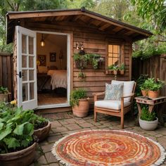 a small wooden shed with potted plants in the corner and an outdoor seating area