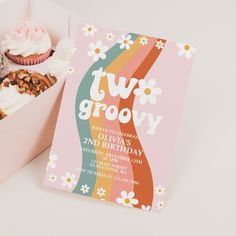 an open box of cupcakes with two grooy on it