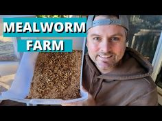 a man is holding up a box full of wood chips and the words mealworm farm