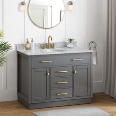 a bathroom vanity with two sinks and a large round mirror above it, along with a rug on the floor