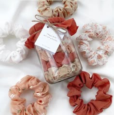 various scrunffles and hair ties in a jar on a white tablecloth