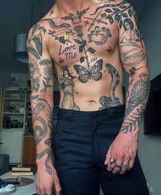 a man with lots of tattoos on his body and chest is posing for the camera