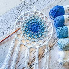 yarn and crochet are laying on the floor next to a white doily