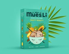 the box for muesli is next to a palm leaf on a blue background