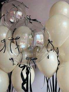 white balloons with black ribbon tied around them