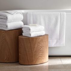 towels are stacked on top of wooden stools