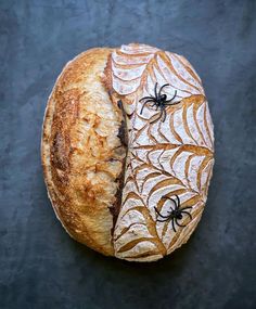 a loaf of bread decorated with spider webs on it's side, sitting on a black surface