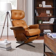 the reclining chair is in front of a book shelf and lamp on top of a table