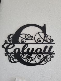 a metal sign that says elbertt hanging on the side of a white wall