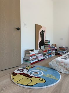 a room with a bed, bookshelf and rugs on the floor in front of it