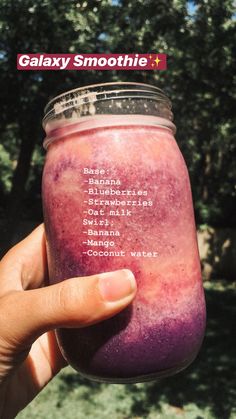 a hand holding up a purple smoothie in a jar with the words galaxy smoothie written on it