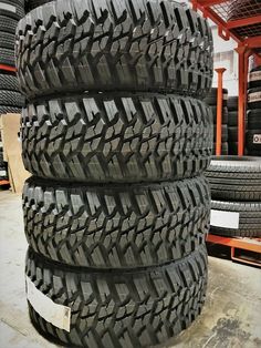 four tires stacked on top of each other in a warehouse