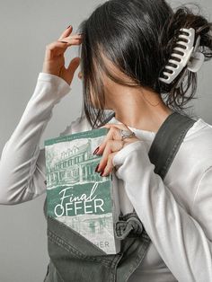 a woman is combing her hair while holding a book