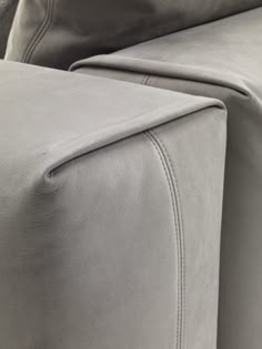 the back end of a grey couch with buttons on it's armrests