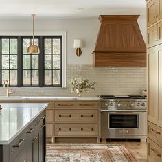 a kitchen with an oven, sink, and stove top on a rug in front of the window