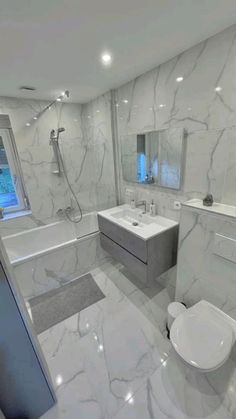 a bathroom with white marble walls and floors