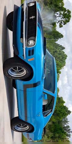 the top view of a blue sports car with its hood up and front wheels down