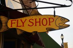 a yellow fish sign hanging from the side of a building