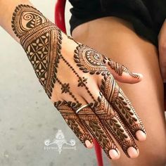 a woman's hand with henna tattoos on it