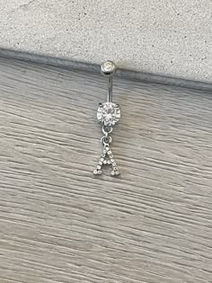 a single crystal letter charm on a wooden surface