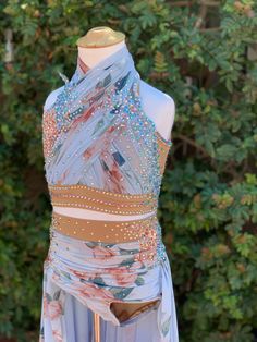 a dress made out of sheer fabric and beads on top of a mannequin