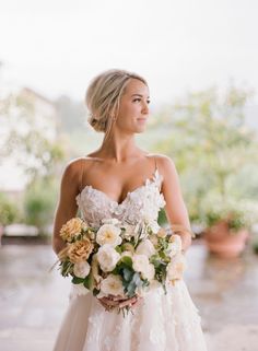 a woman in a wedding dress holding a bouquet