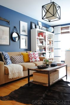 a living room filled with furniture and pictures hanging on the wall above a coffee table