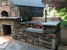 an outdoor grill built into the side of a stone building