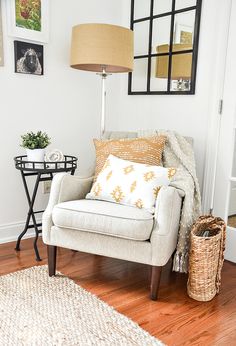 a living room with a chair, lamp and pictures on the wall