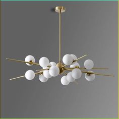 a chandelier with white glass balls hanging from it's brass finish frame