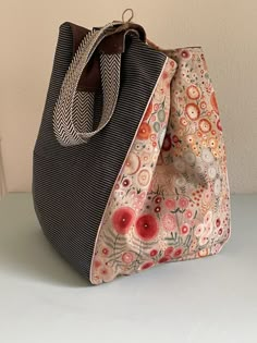 a handbag is sitting on a table with a white wall in the back ground