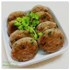 some food is in a white dish on a table with green garnishes