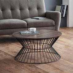 a coffee table sitting on top of a hard wood floor next to a gray couch