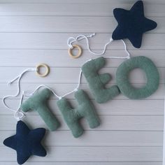 the word oh spelled out with felt stars hanging from it's sides on a white wall