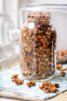 a glass jar filled with granola sitting on top of a table