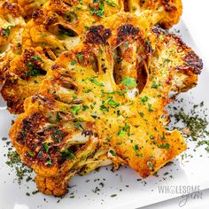 roasted cauliflower with herbs and seasoning on a white platter, ready to be eaten