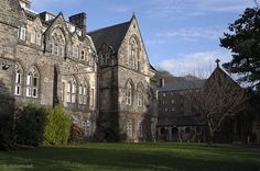 an old building with many windows and grass