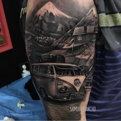 a man with a tattoo on his arm has a vw bus in the mountains