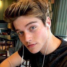 a young man with headphones on sitting at a table