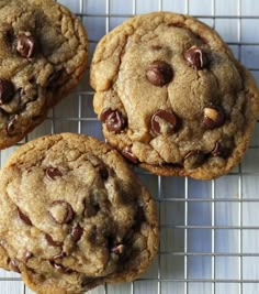 three chocolate chip cookies cooling on a wire rack