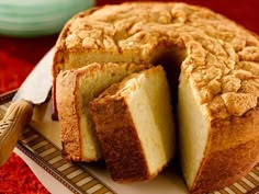 a cake that has been cut into pieces on a plate with a knife next to it