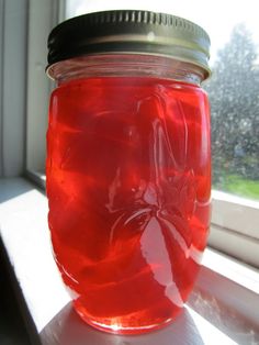 a jar filled with liquid sitting on top of a window sill