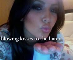 a woman blowing kisses to the haters with her tongue out and text below it