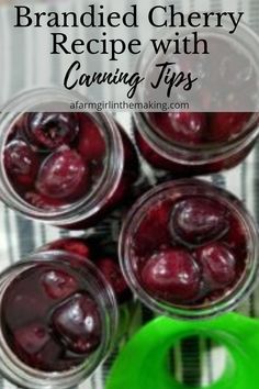 jars filled with cherries sitting on top of a table