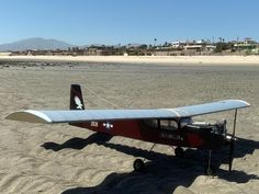 a small airplane sitting on top of a sandy beach