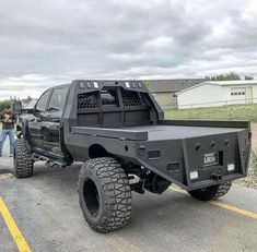 the truck is parked on the side of the road with two people standing around it