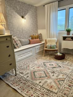 a living room with a large rug on the floor next to a chair and window